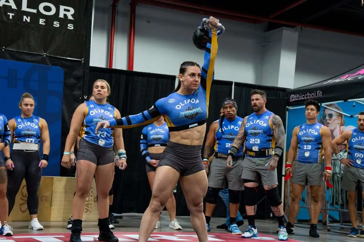 A Tampa Bay Brigade player locks out a single-arm kettlebell snatch with teammates watching during the Lions vs Brigade 2026 Grid League season opener in Miami