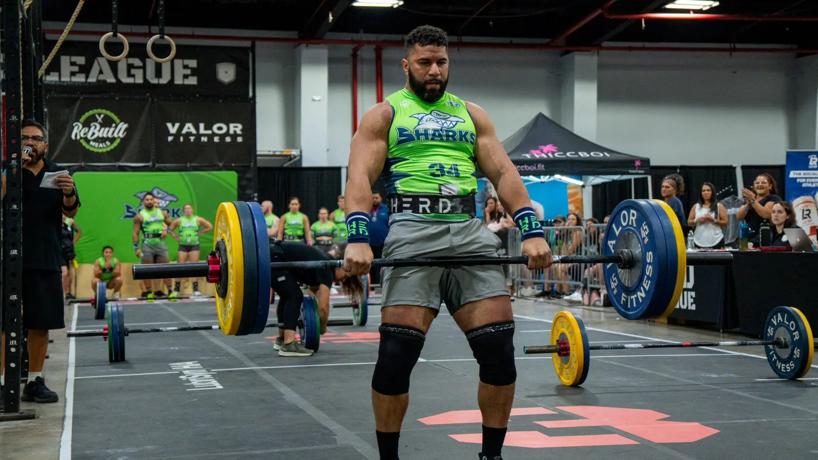 A Sharks athlete sets up to deadlift a loaded barbell at the Grid League season opener in Miami.