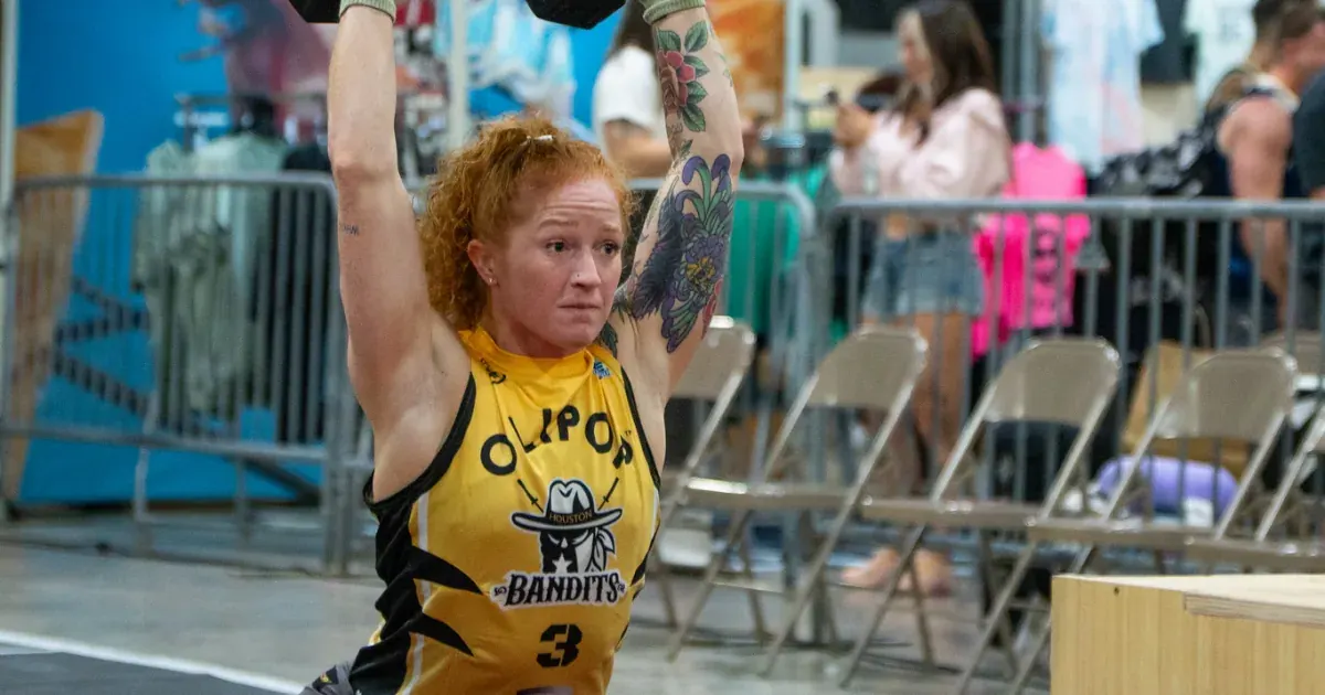 A Houston Bandits athlete presses a pair of dumbbells overhead during the 2026 United Grid League opening day in Miami.