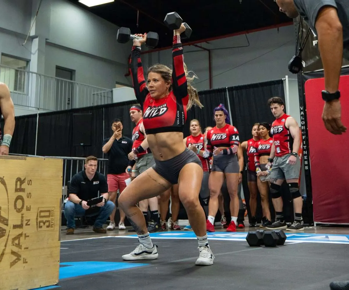 Atlanta Wild player locks out two dumbbells overhead with the Wild bench watching during the Wild vs Venom 2026 Grid League season opener in Miami