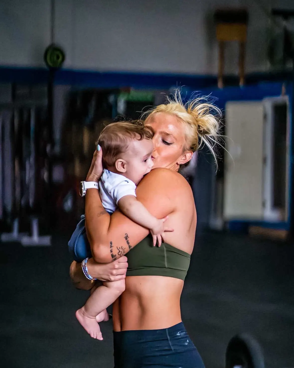 Carolina Flight rookie HaleiJo Fuller-Arroyo kisses her son Landon between training sets in the gym.