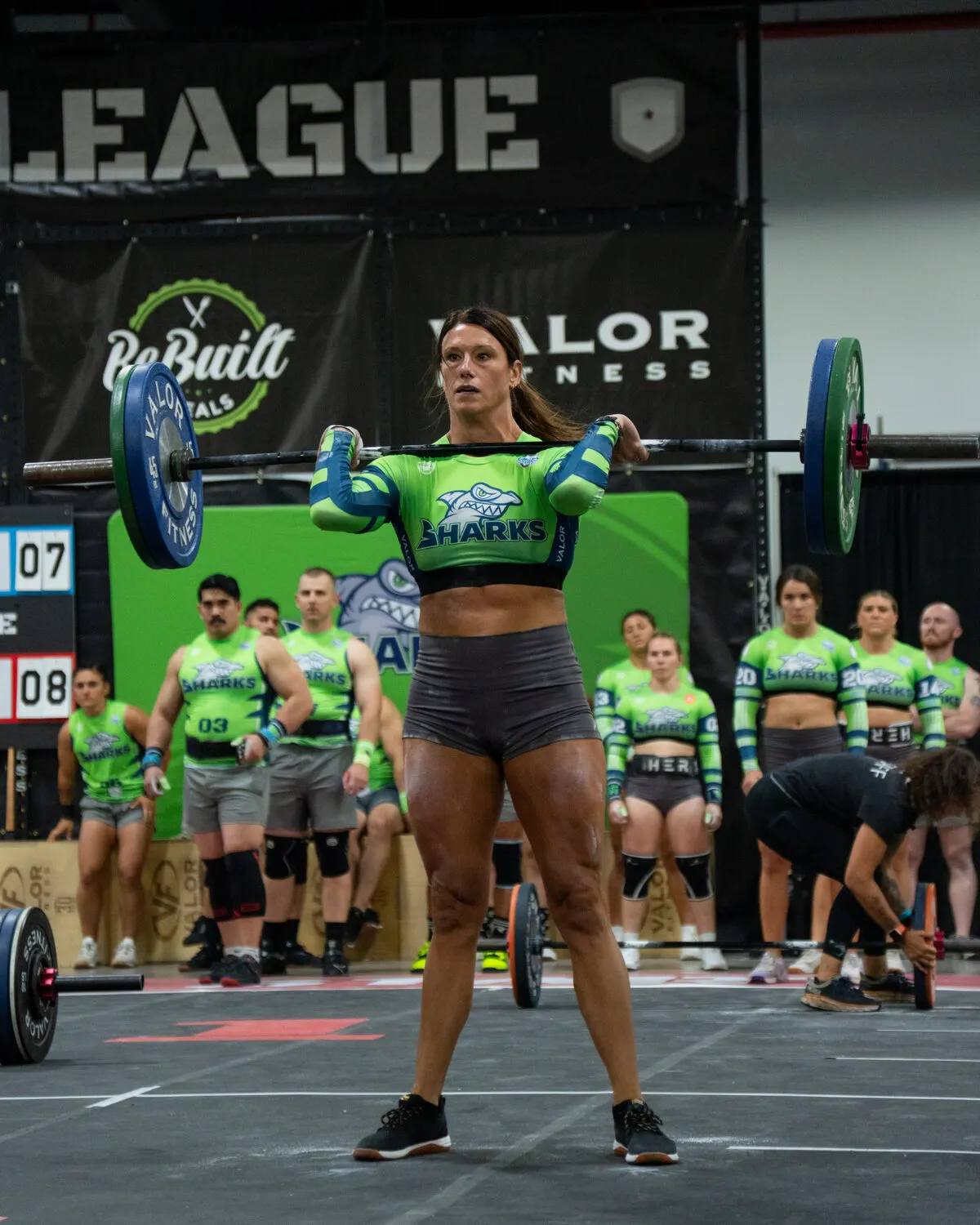 A Sharks athlete holds a barbell in the front rack during the Grid League season opener in Miami.