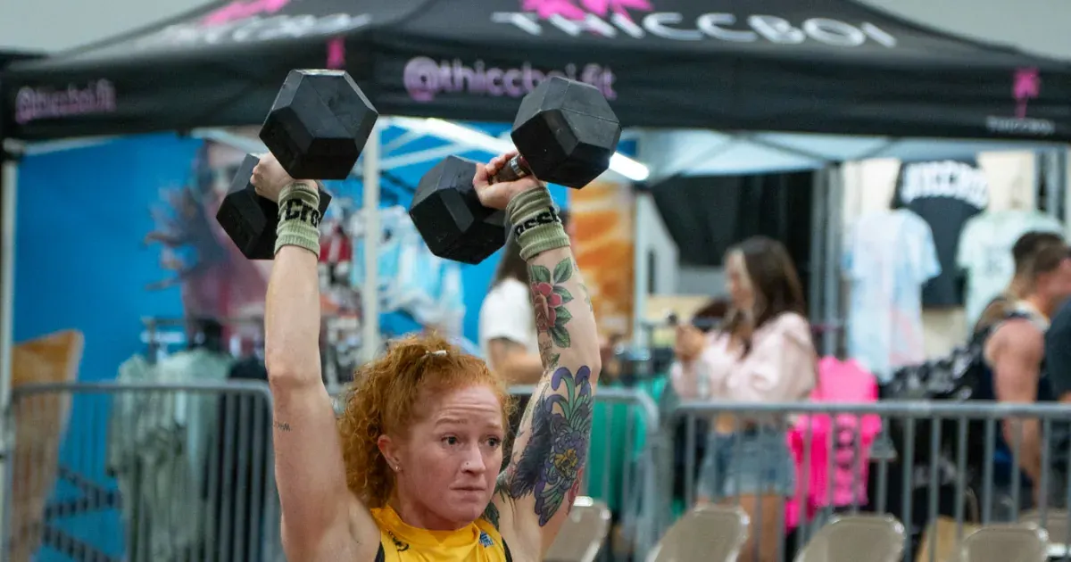 A Houston Bandits athlete presses a pair of dumbbells overhead during the 2026 United Grid League opening day in Miami.