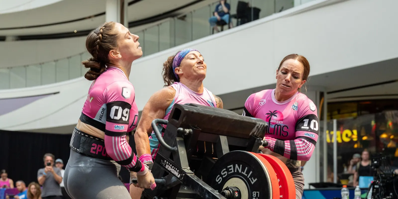 Three South Beach Palms athletes push a loaded sled at United Grid League Week 3 at American Dream.