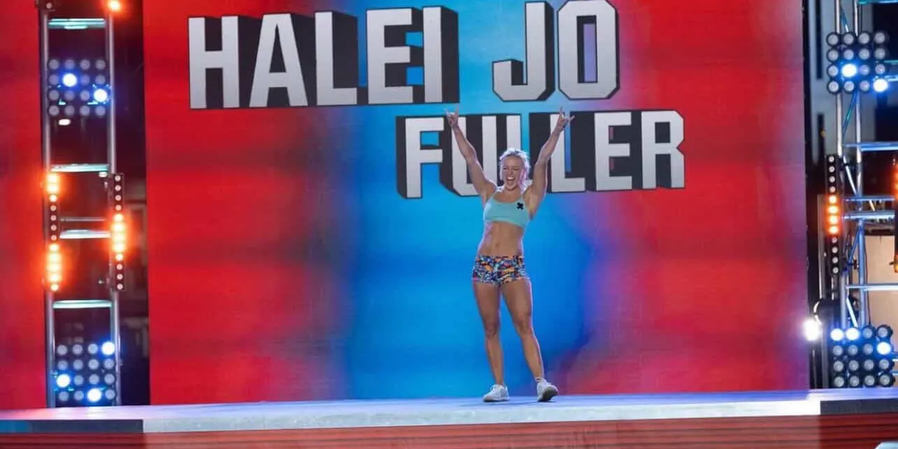 Carolina Flight rookie HaleiJo Fuller-Arroyo raises her arms on the American Ninja Warrior stage in front of her name on the big screen.