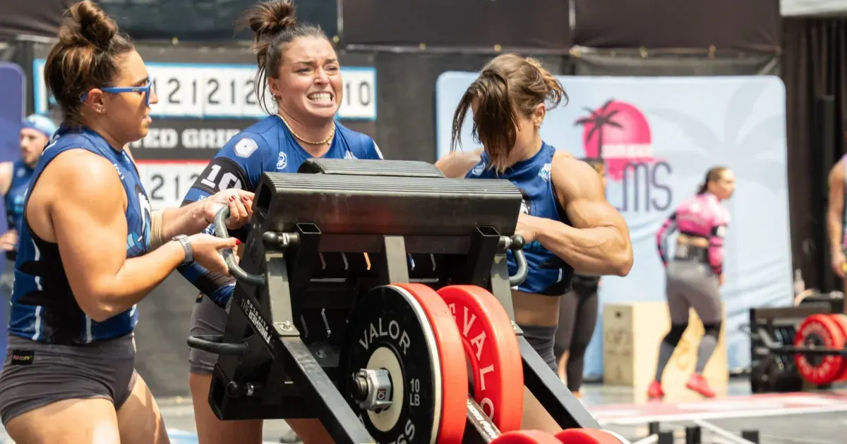 Three Palm Beach Breakers athletes push a loaded sled at United Grid League Week 3 at American Dream.