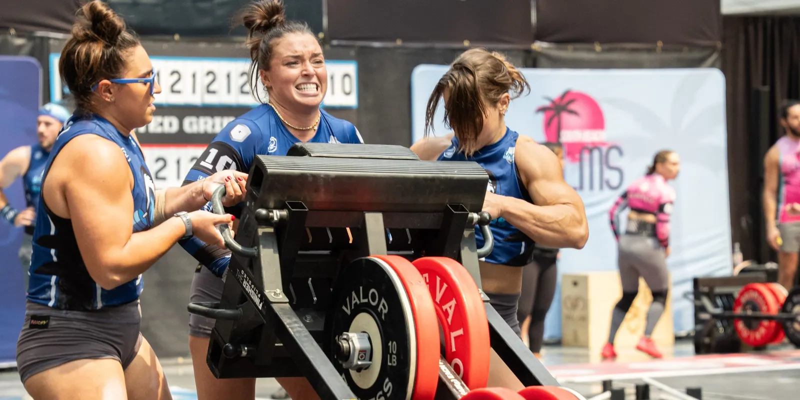 Three Palm Beach Breakers athletes push a loaded sled at United Grid League Week 3 at American Dream.