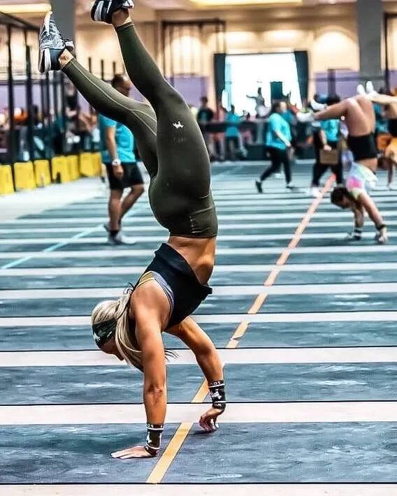 Carolina Flight rookie HaleiJo Fuller-Arroyo handstand walks down a competition floor lane.